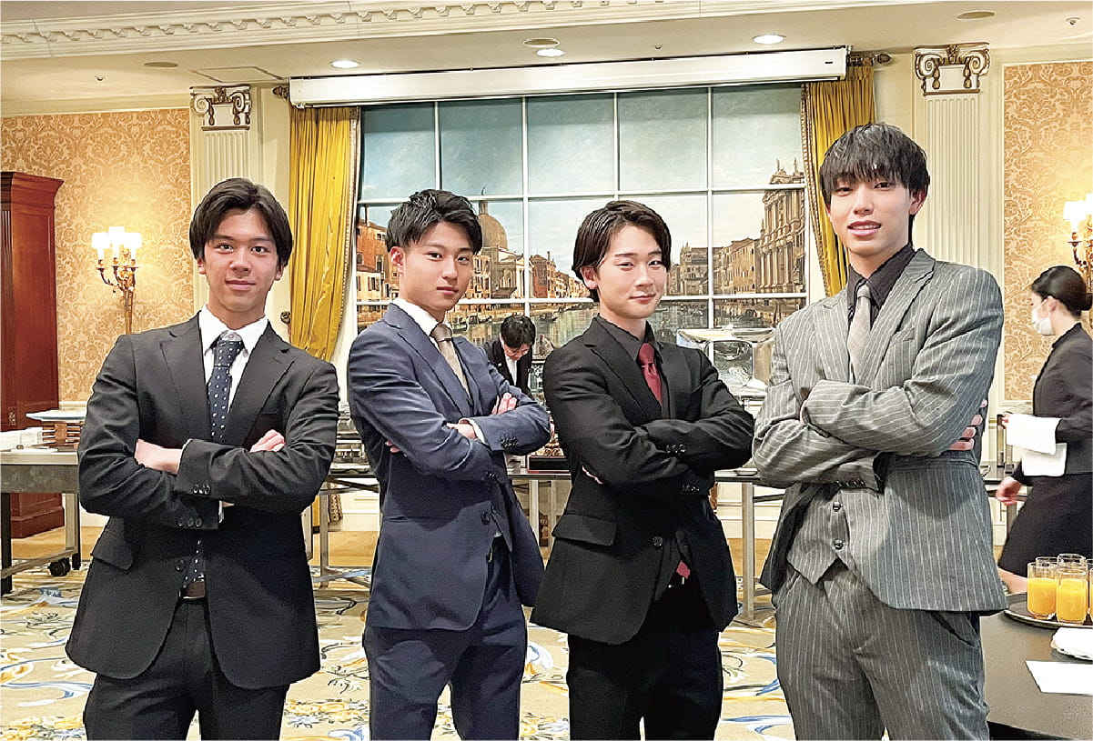 立食パーティー 男性四年が腕を組んでいる様子